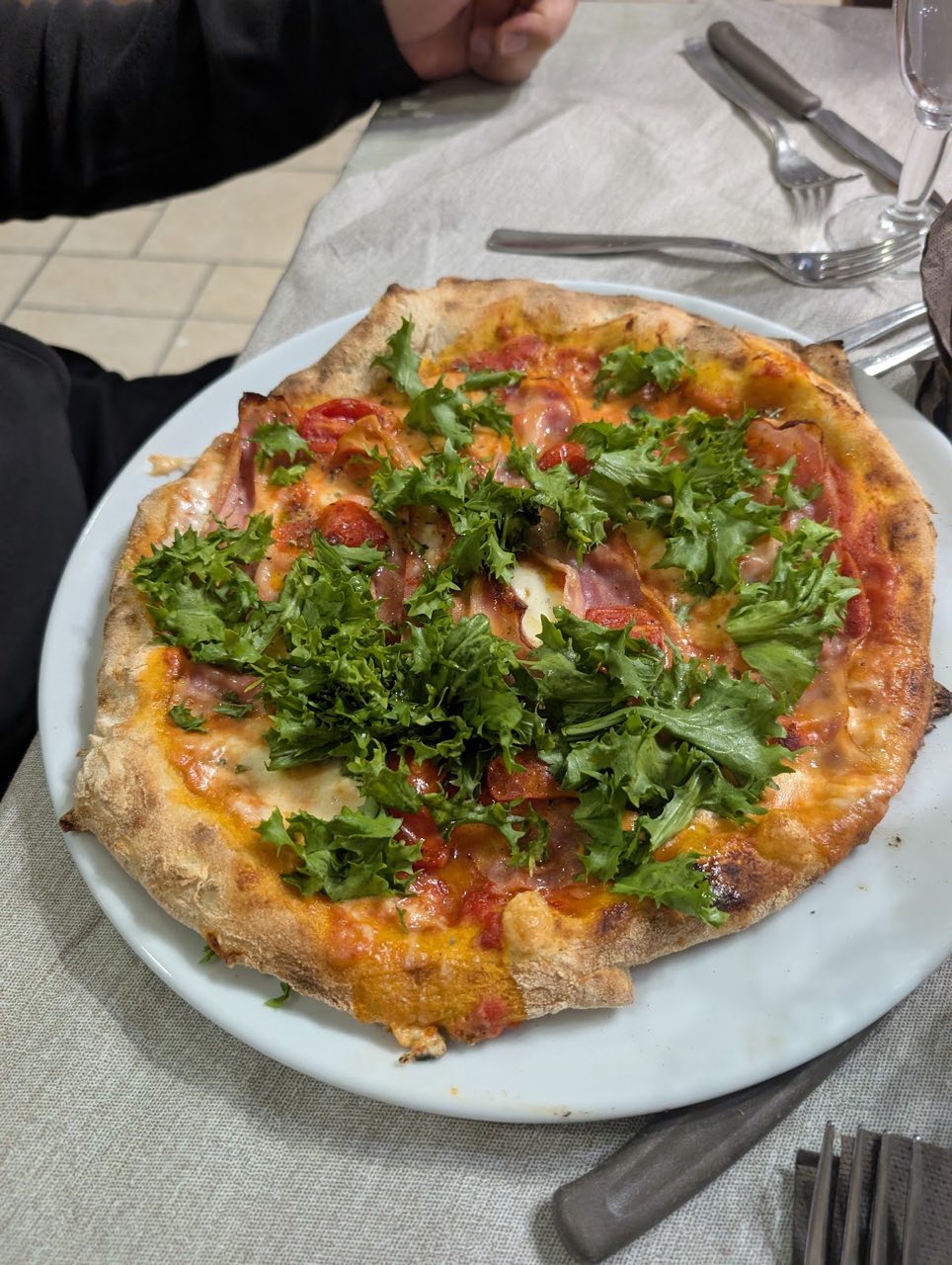 Pizza con prosciutto, pomodorini e rucola
